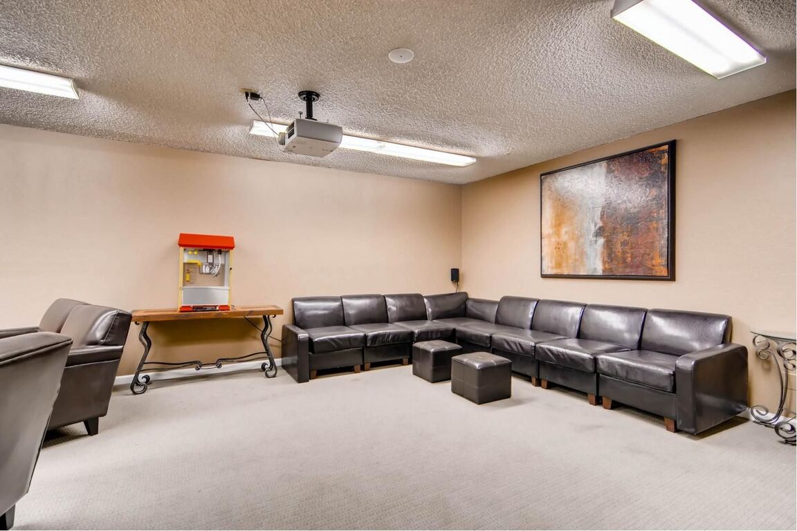 Clubhouse with large sectional sofa, projector, and popcorn machine